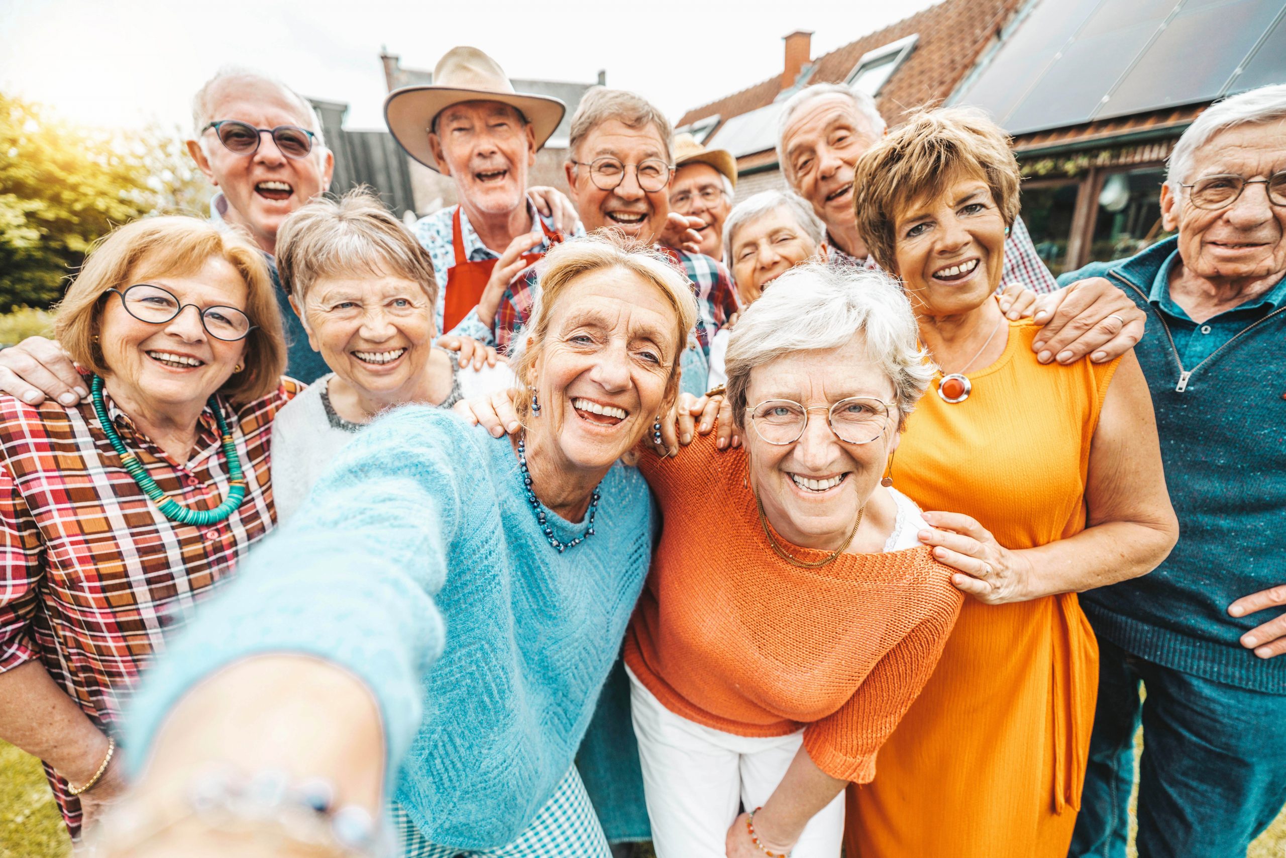 Happy group of senior people smiling at camera outdoors - Older friends taking selfie pic with smart mobile phone device - Life style concept with pensioners having fun together on summer holiday